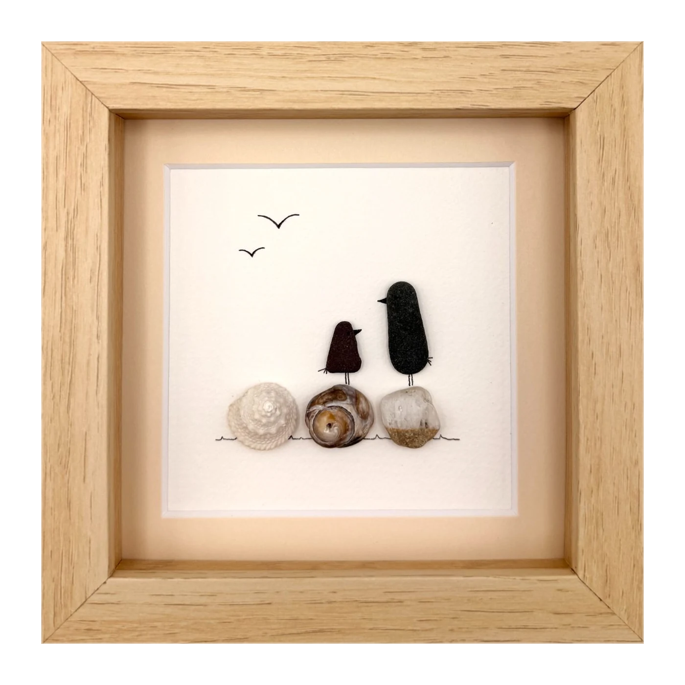 Two dark sea glass birds on shells