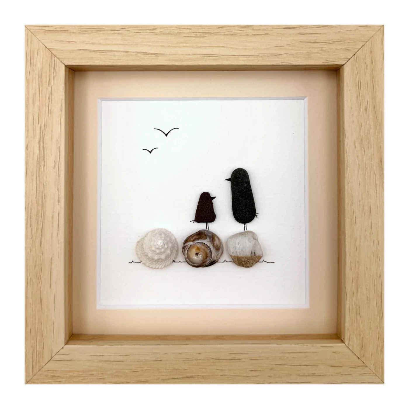 Two dark sea glass birds on shells