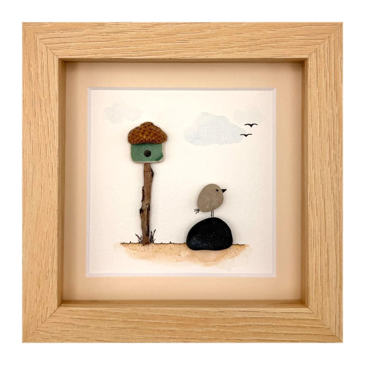 Pebble bird beside an acorn birdhouse