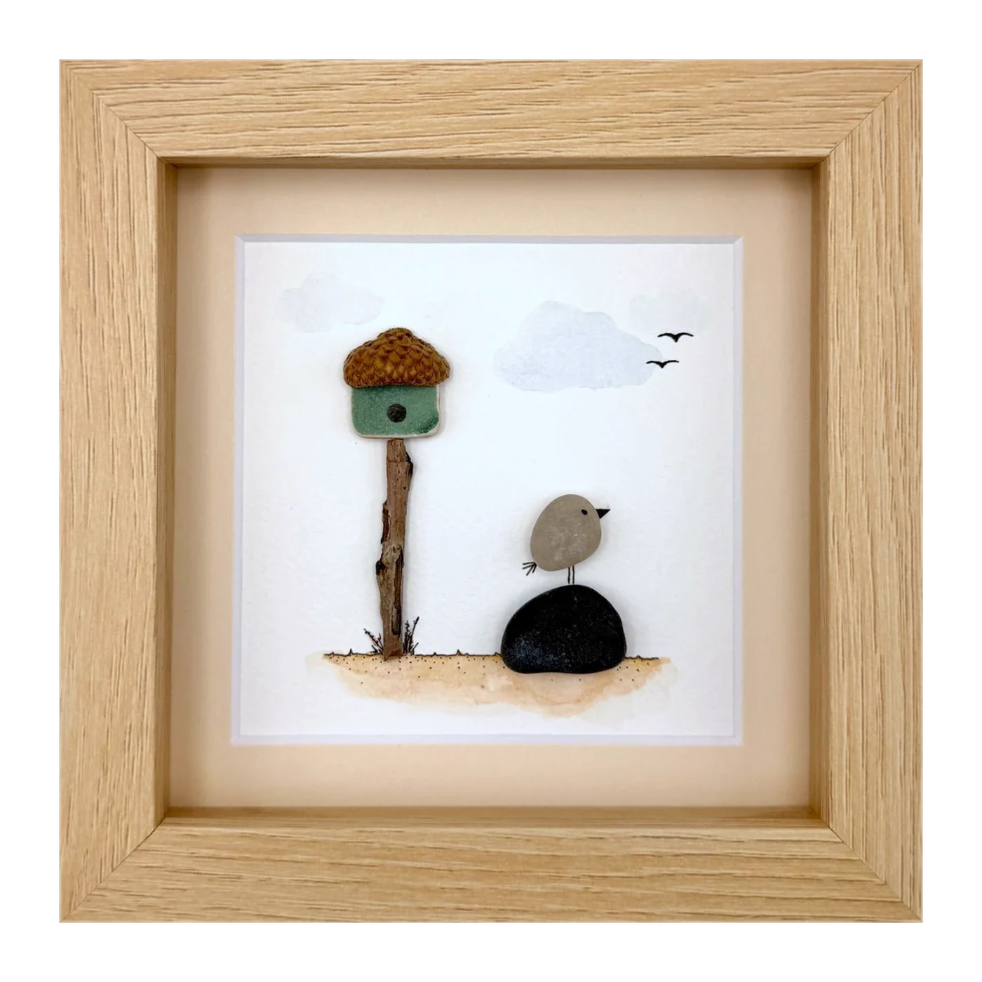 Pebble bird beside an acorn birdhouse