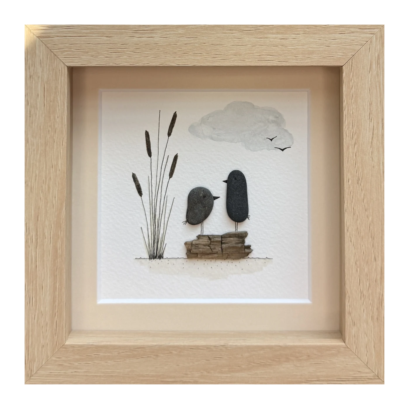 Two dark stone birds side by side on a driftwood log, with cattails and a passing cloud