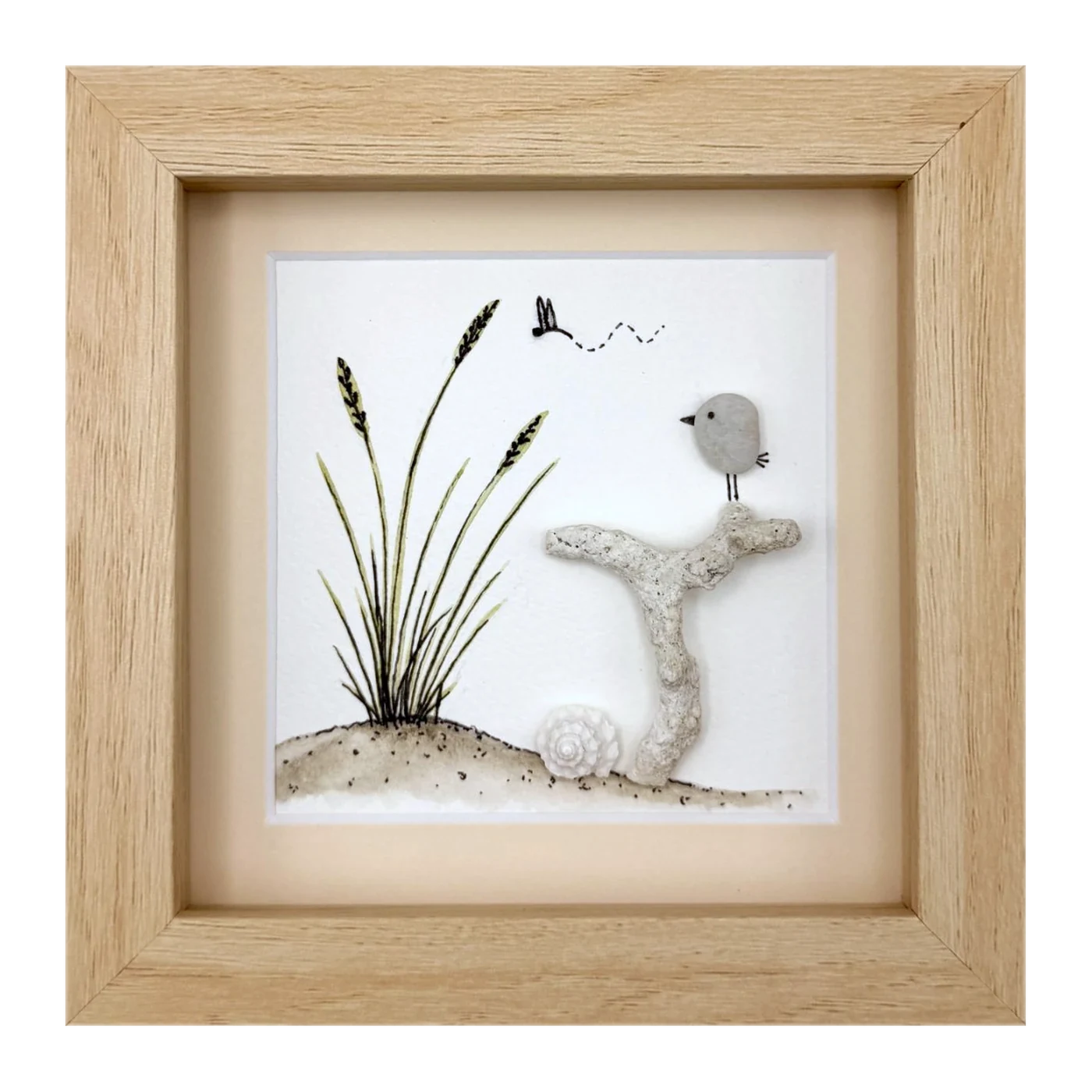 A pebble bird on coral beside dune grass