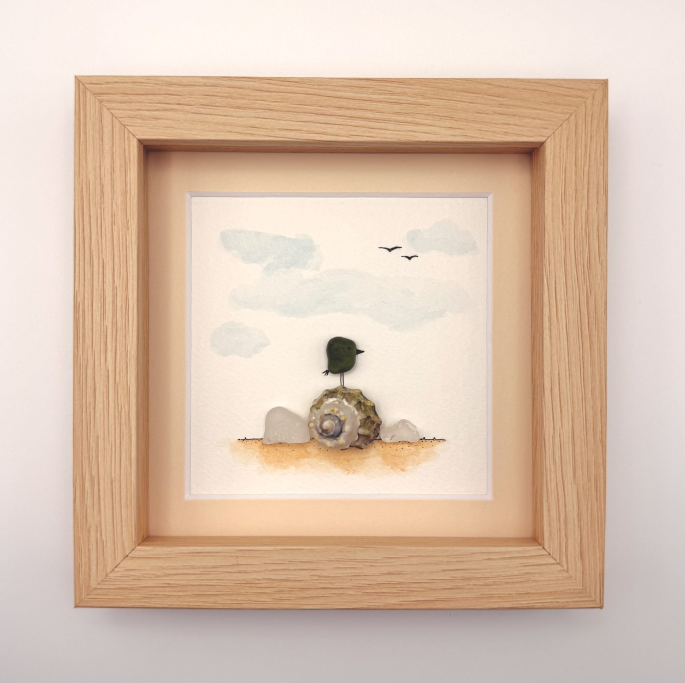 Green sea glass bird on a snail shell