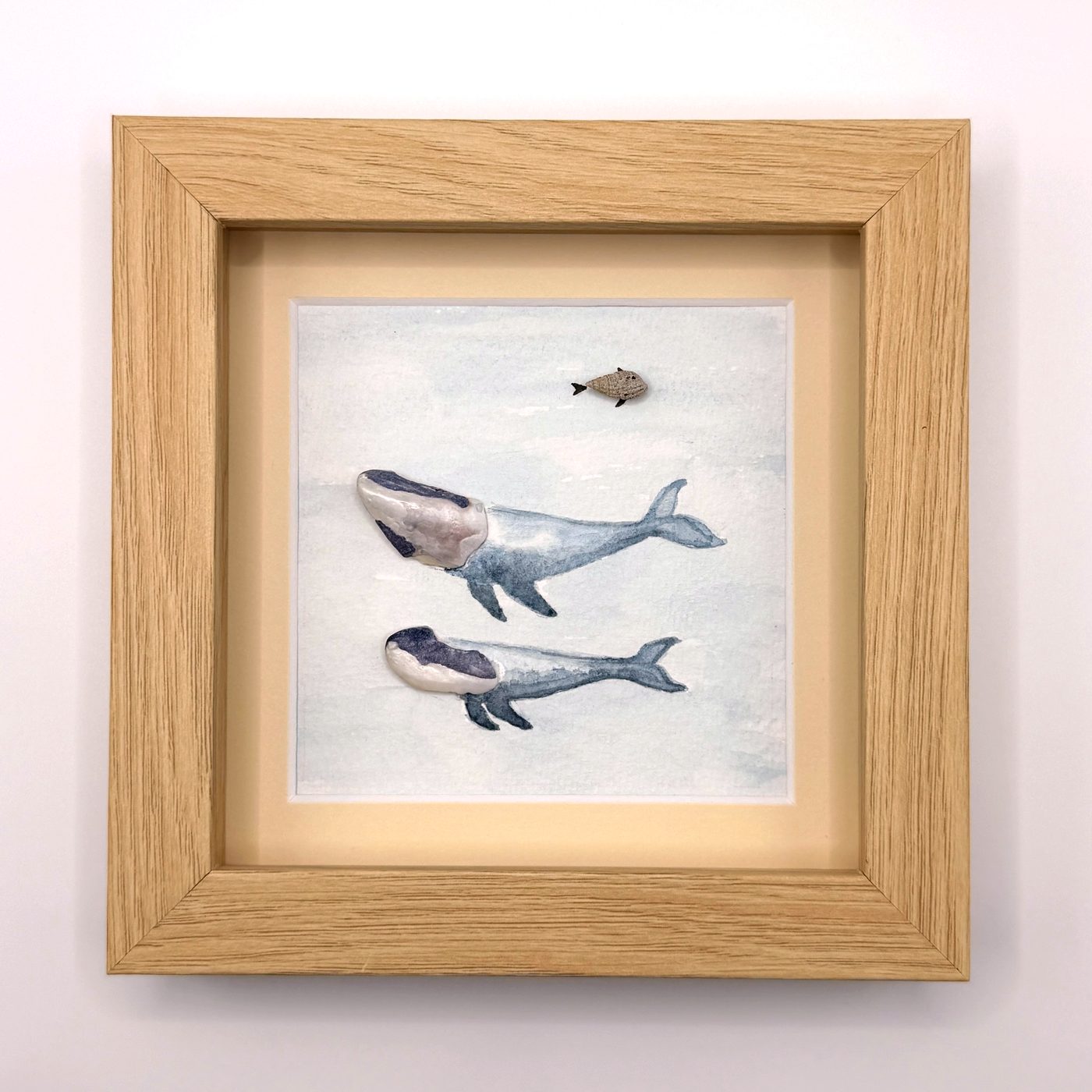 Two shell whales with a small pebble fish above them